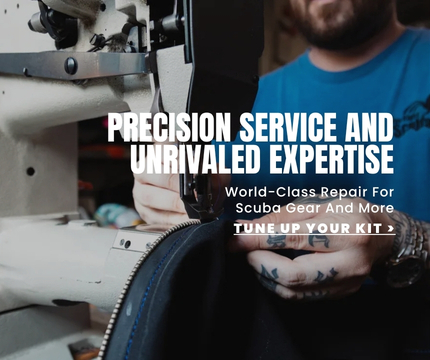 A drysuit technician sewing a zipper onto a drysuit.